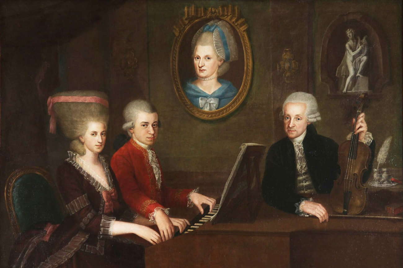 Wolfgang Amadeus Mozart mit Schwester Maria Anna und Vater Leopold, an der Wand ein Portrait der verstorbenen Mutter, Anna Maria. Gemalt von Johann Nepomuk della Croce. | Wikicommons, gemeinfrei