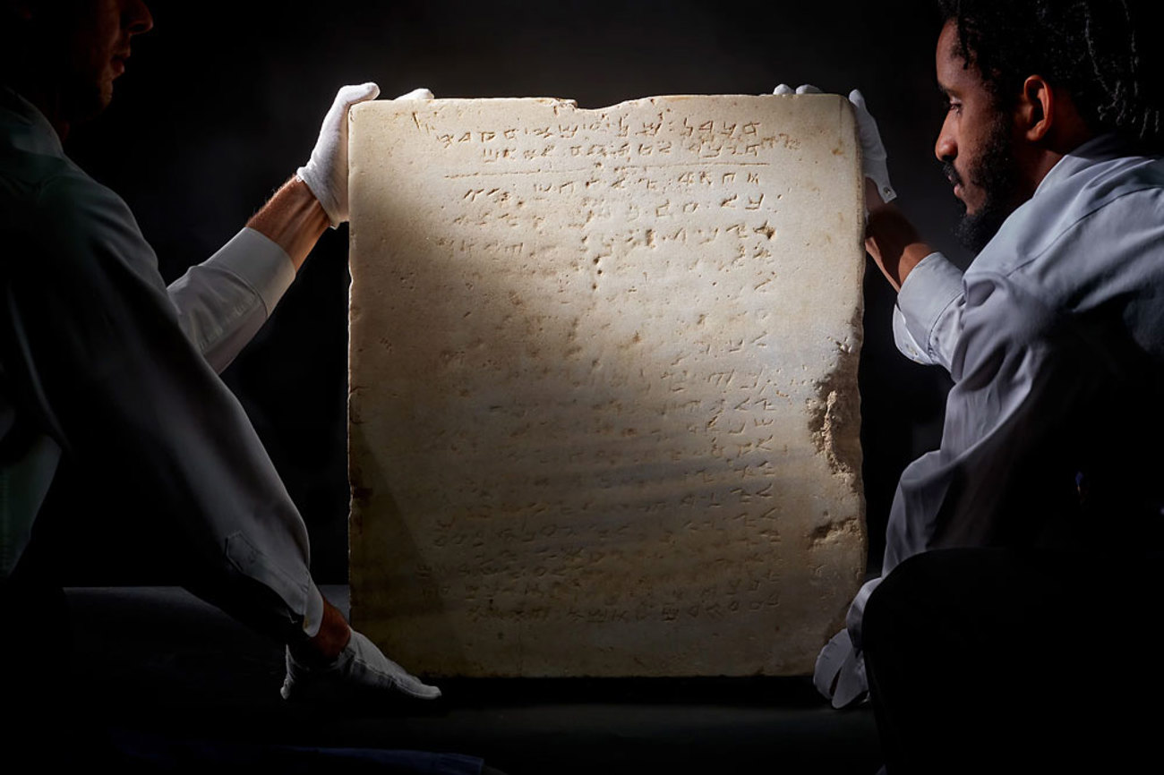 Mitarbeiter des Auktionshauses Sotheby's präsentieren die Marmortafel mit den Zehn Geboten. Foto: Sotheby's