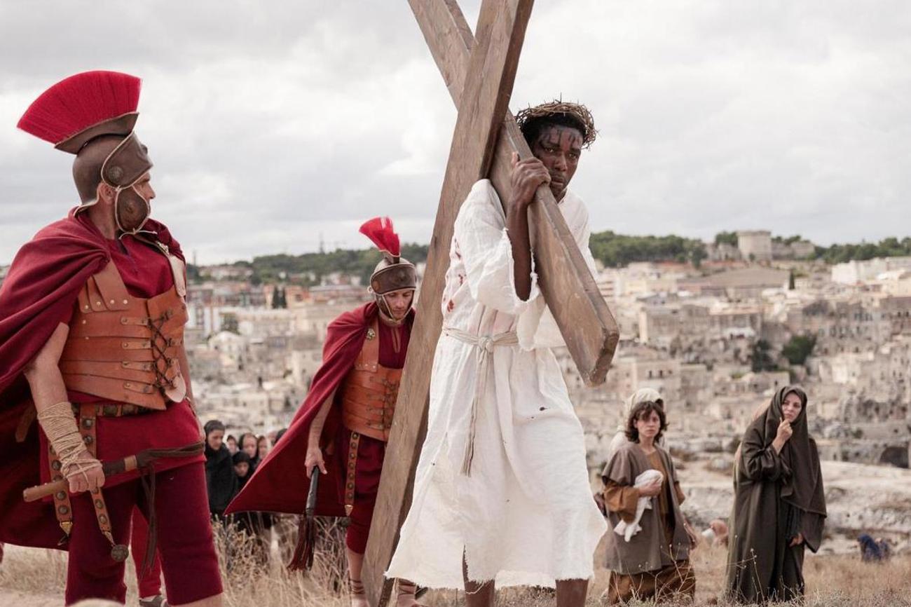 Jesus (Yvan Sagnet) trägt in Milo Raus Film «Das Neue Testament» das Kreuz. | Fruitmarket/Langfilm